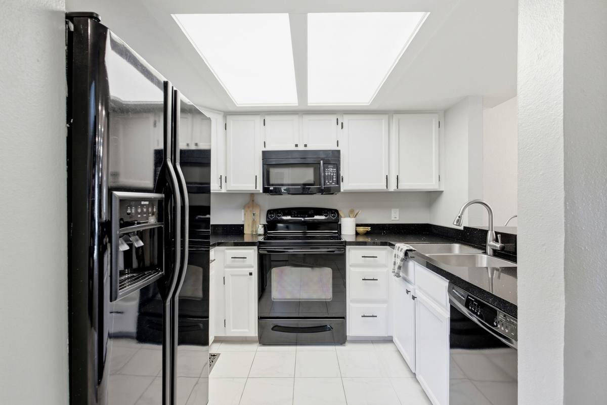 Galley kitchen lit by a large flush ceiling light panel