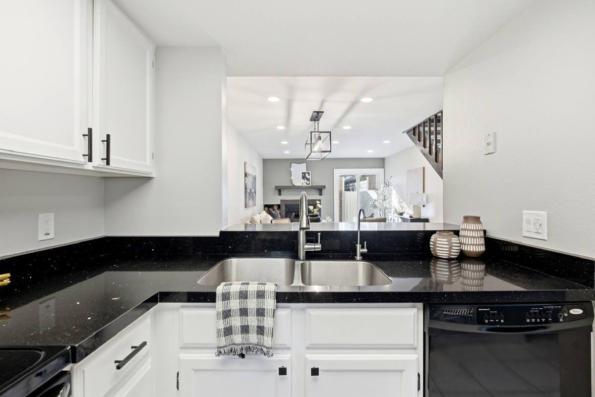 Kitchen and living space with recessed ceiling lights and a caged pendant light over the dining area